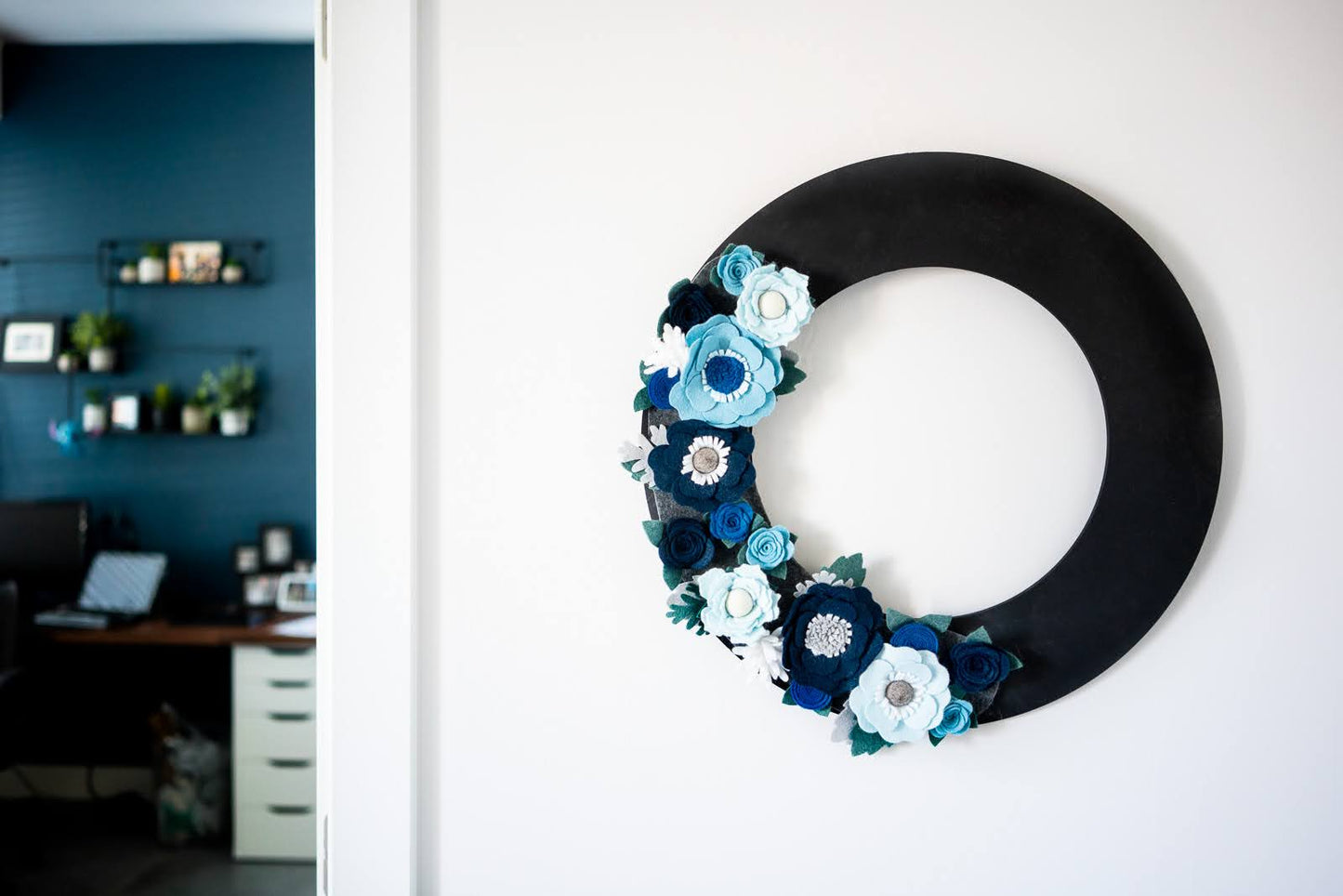Elevate your holiday decor with the Winter Wreath Attachment, a stunning addition to your seasonal collection. This wreath features frost-bitten flowers in varying shades of blue, elegantly arranged on a soft grey background, evoking the serene beauty of winter. Crafted from durable, eco-friendly materials, it’s a reusable and sustainable choice for those seeking non-plastic alternatives. Pair it with our merino wool felt gift bows for a cohesive, winter-inspired look.