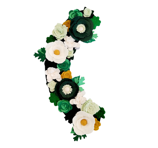 This charming St. Patrick's Day wreath attachment features an array of felt flowers in green, white, and gold, celebrating the spirit of the holiday.