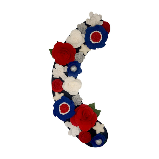 4th of July interchangeable wreath attachment with red roses, white stars, and red, white, and blue flowers on a black felt background.