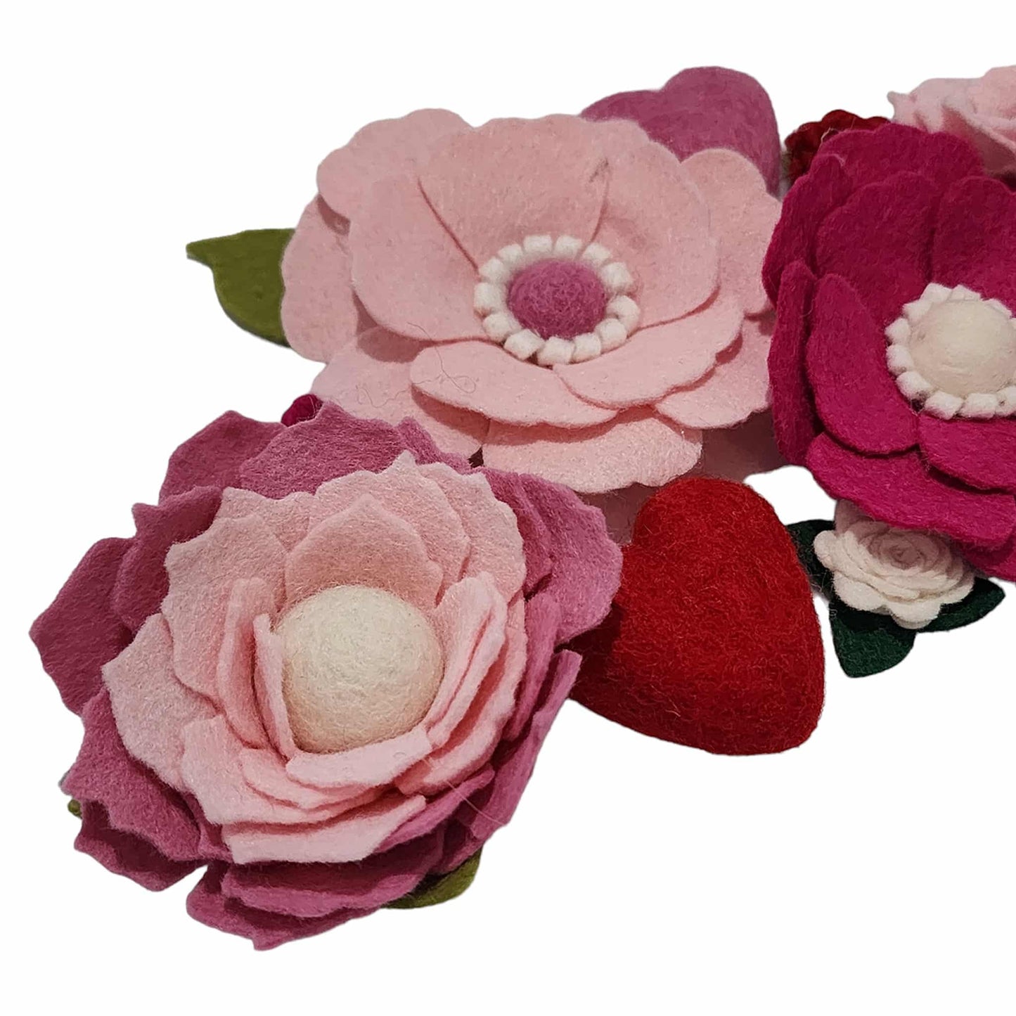 A close up of the valentines wreath attachment showing the felted heart and variation of pink flowers.