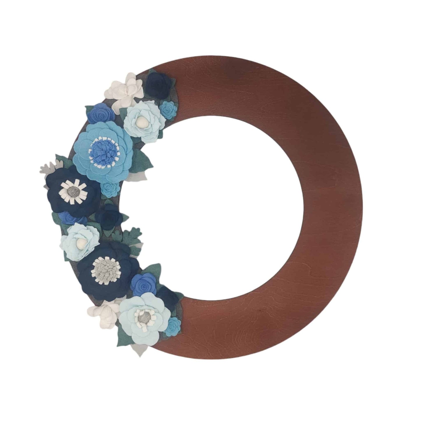 A close-up of the Winter | Standard Wreath Attachment on a gray background. The handmade arrangement showcases large, intricately crafted flowers in shades of blue, white, and gray. Green Eco-Fi felt leaves are interspersed among the flowers, enhancing the visual appeal of the design.