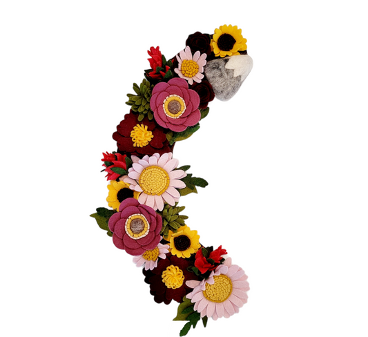 Green sprigs of evergreen and small pinecones are interspersed, evoking the lush landscape of Mount Rainier.