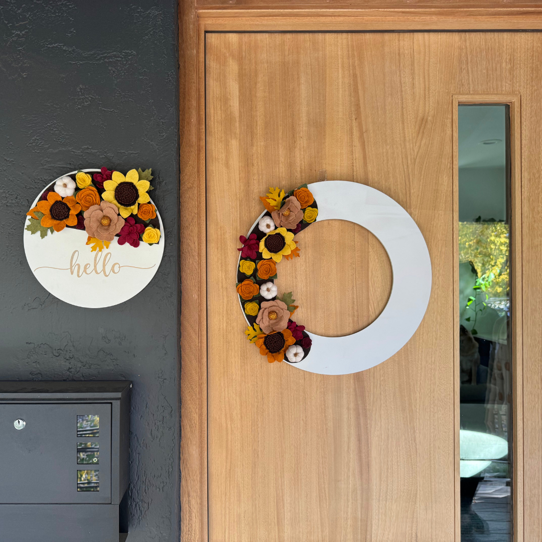 Capture the beauty of fall with the Autumn Wreath Attachment, a stunning seasonal accent perfect for your decor. This wreath is adorned with sunflowers, pumpkins, and a variety of autumn-colored flowers, all arranged on a rich brown background to evoke the warmth and vibrancy of the season.