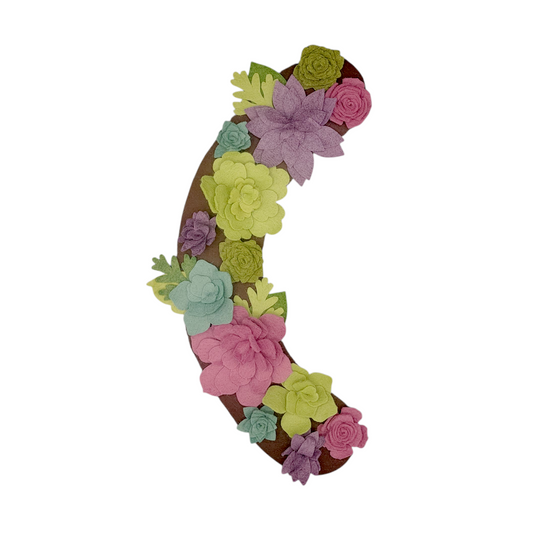 The Summer wreath attachment is adorned with a large array of succulents in teal, green, purple, and pink on a brown background. 