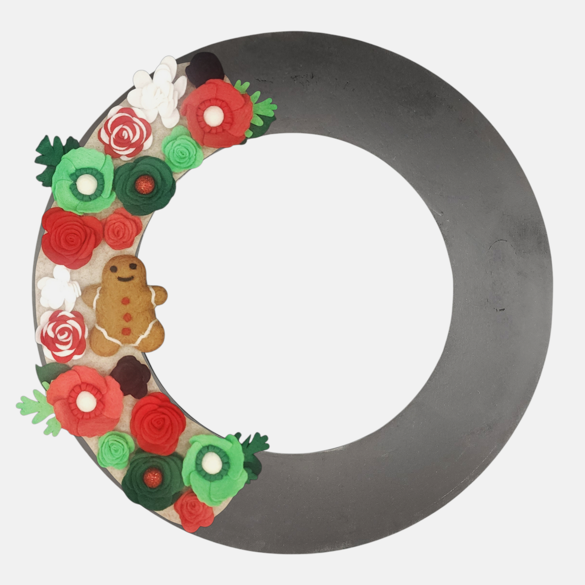 Sustainable and interchangeable wreath adorned with red and white candy cane flowers, bright green and red petals, and a gingerbread charm on a beige background on a black wreath base