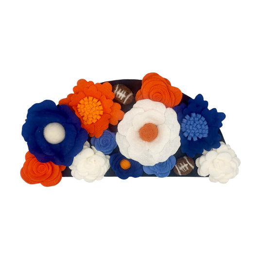 Wreath attachment featuring a football design surrounded by layered greenery and bold orange and navy accents on a neutral base.