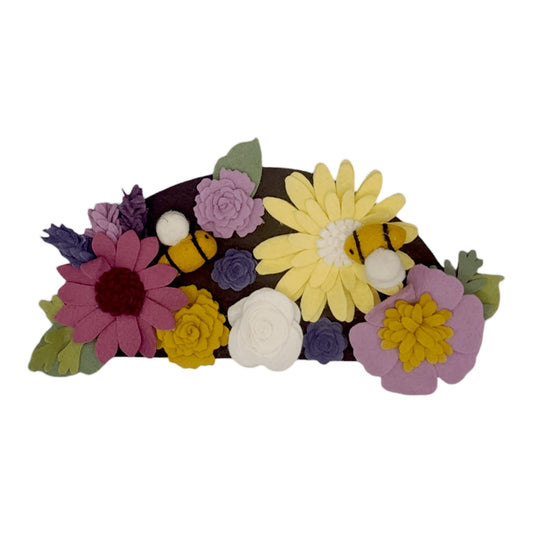 Wreath attachment with bumblebees and colorful flowers in purple, yellow, and linen on a brown background, supporting pollinator protection.