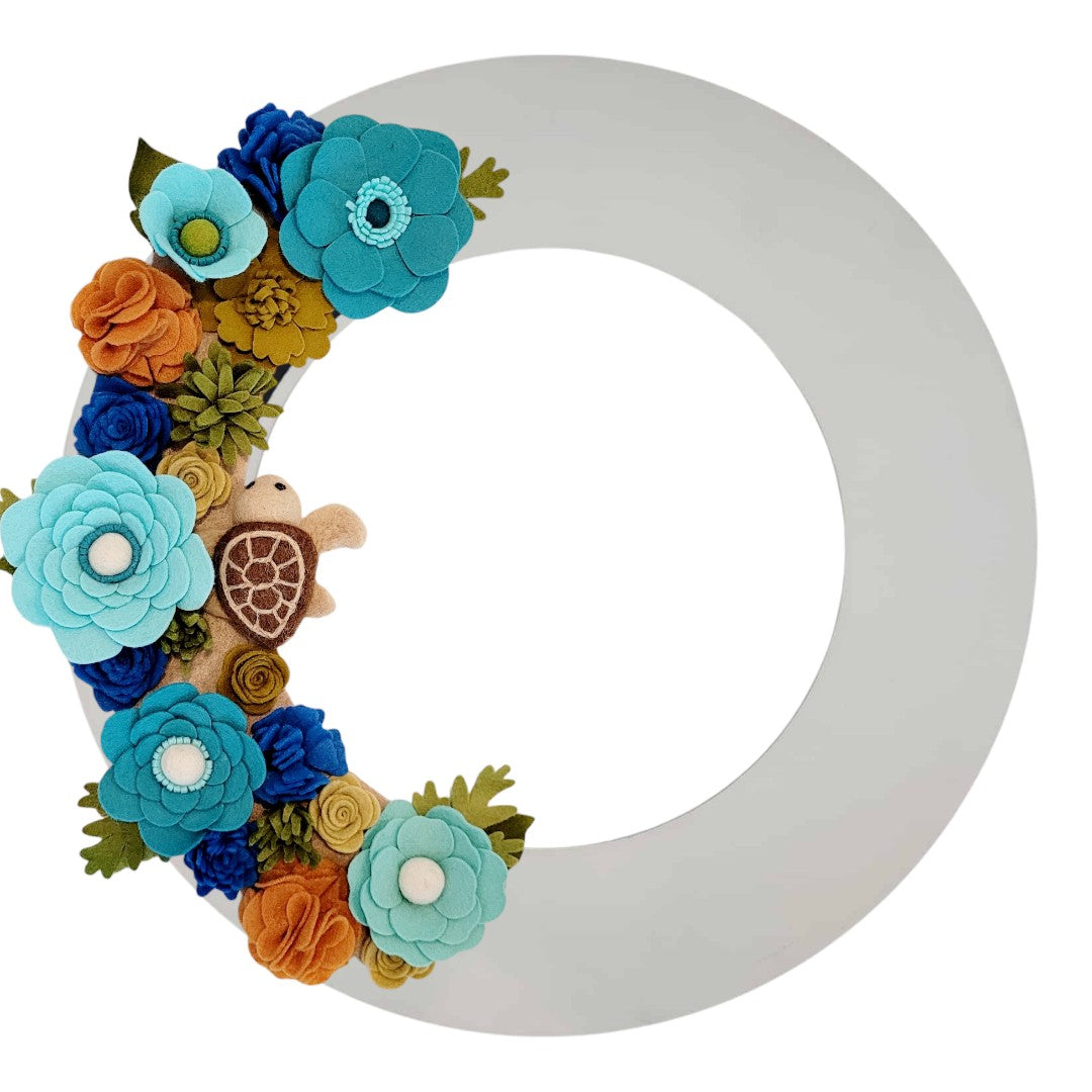 An eco-friendly wreath supporting the "Save the Sea Turtles" cause, featuring bright teal, green, and brown felt flowers.