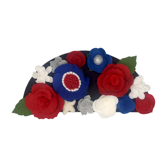 Wreath attachment featuring bold red, white, and blue florals surrounded by patriotic ribbon and star accents on a natural base.