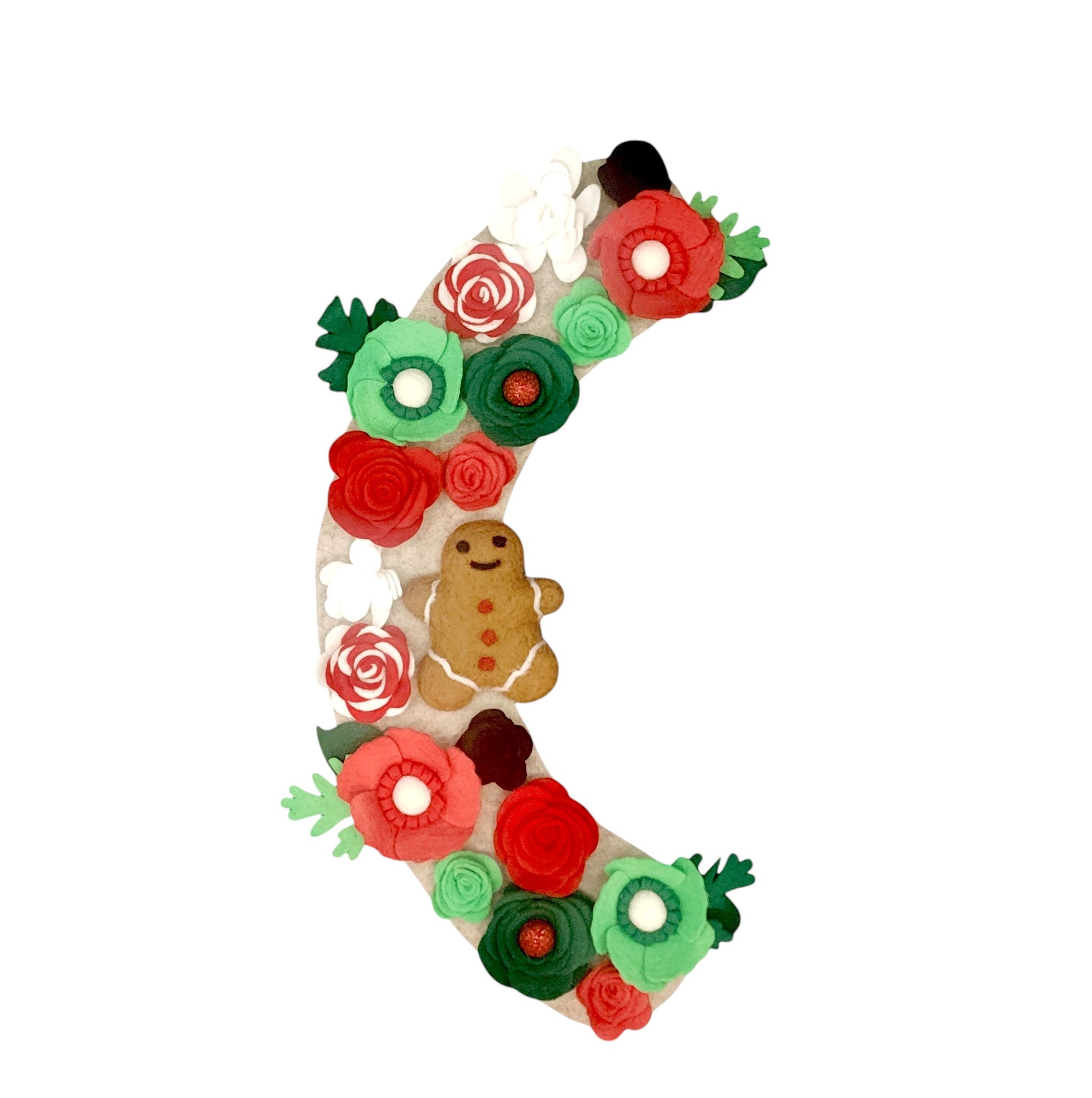 Limited Edition Eco-friendly wreath with red and white candy cane flowers, whimsical green and red blooms, and a festive gingerbread accent on a beige background.