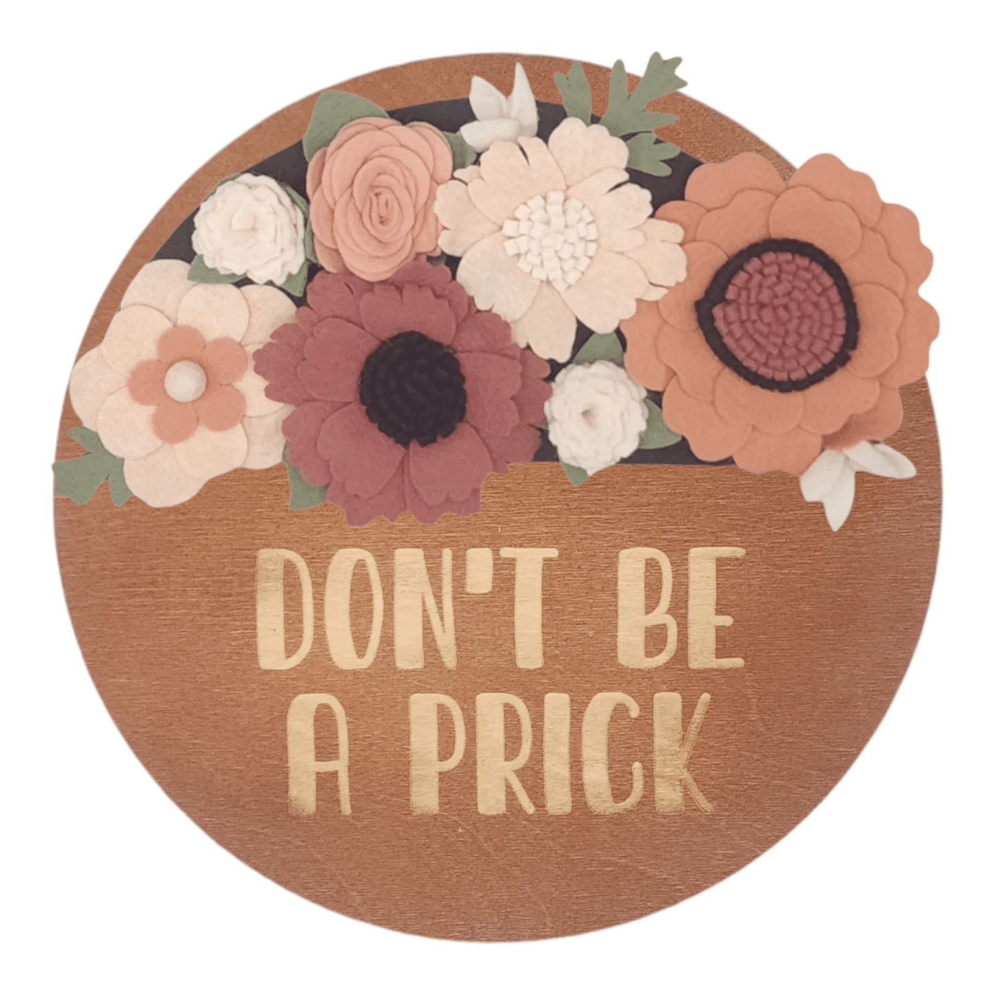 Spring wreath featuring felt flowers in variation of pink and white on a round walnut base reading "DON'T BE A PRICK".