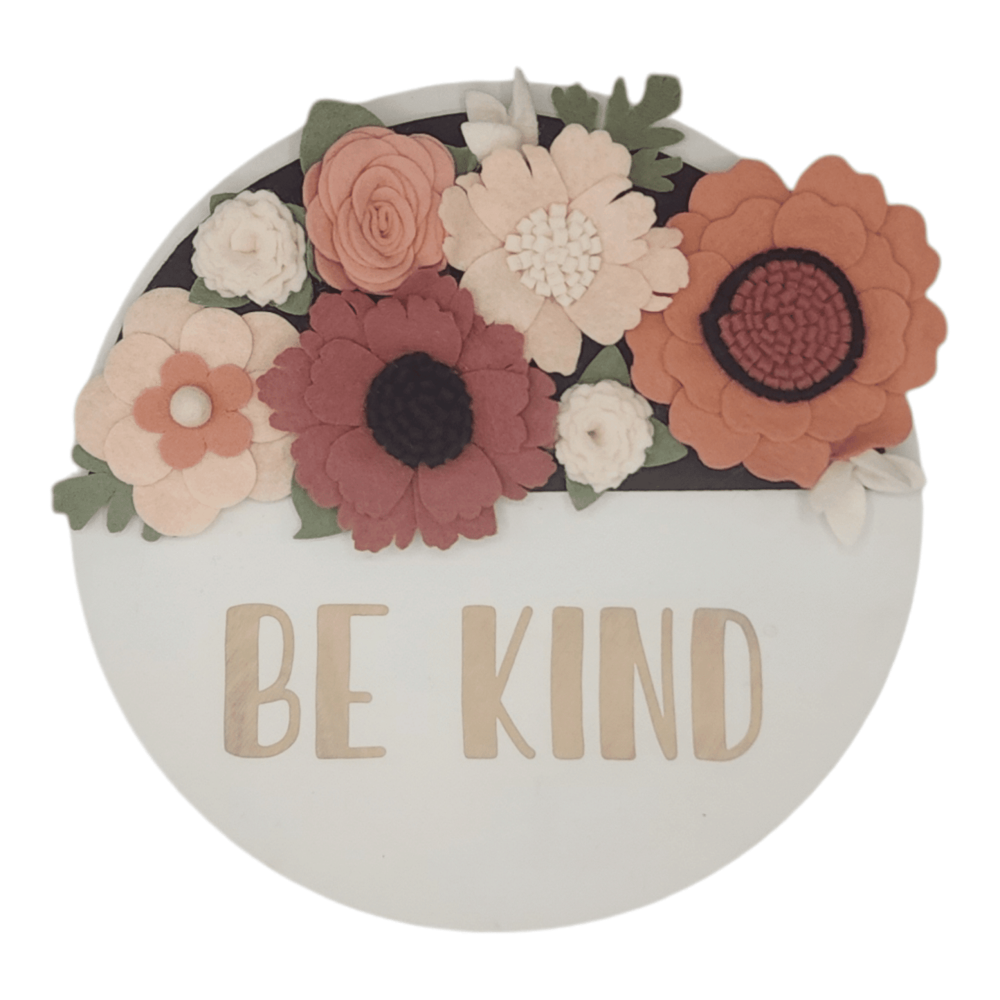 Spring wreath featuring felt flowers in variation of pink and white on a round white base reading "BE KIND".