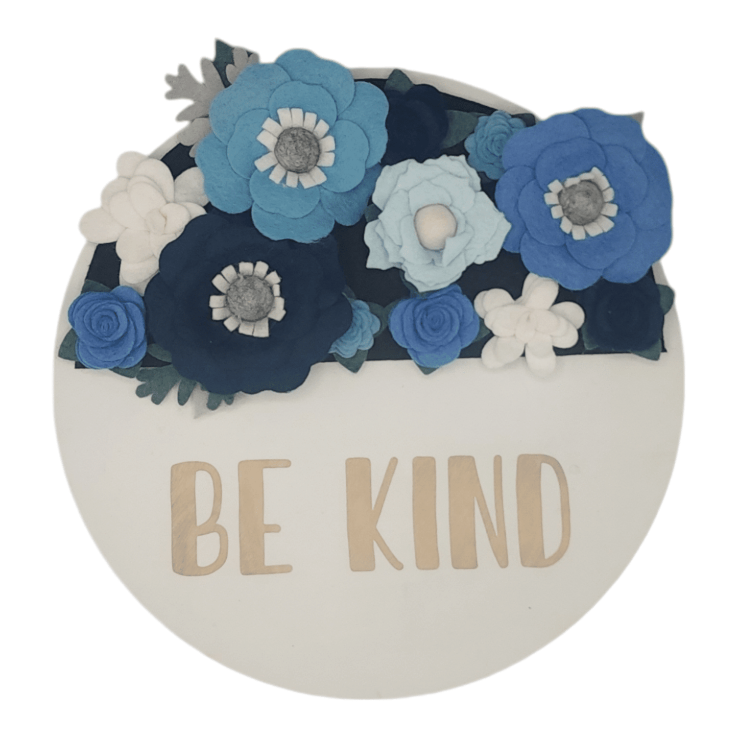 Winter wreath is a winter wonderland of blue and white felt flowers on a round white base reading "BE KIND".