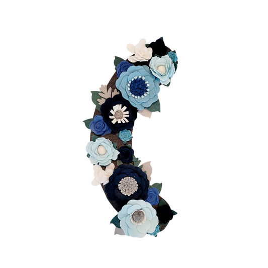 The Winter wreath attachment is covered in frost-bitten flowers in different shades of blue on a grey background. 