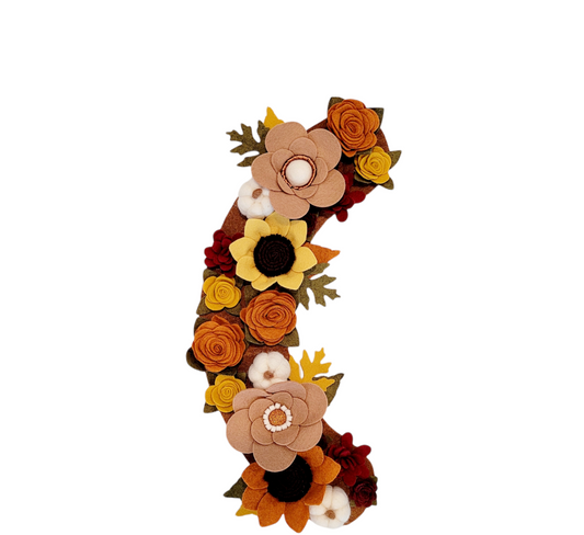The Autumn wreath attachment is covered in sunflowers, pumpkins, and other autumn-colored flowers on a brown background. 