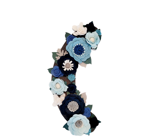 The Winter wreath attachment is covered in frost-bitten flowers in different shades of blue on a grey background. 
