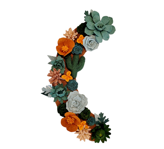 Arizona wreath attachment is covered in teal and green succulents, orange poppies, cacti and mallow flowers on a brown background.